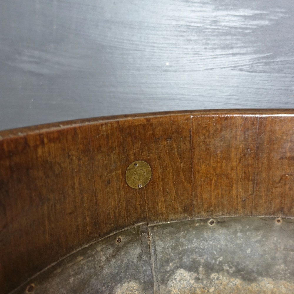 An eighteenth-century oval mahogany wine cooler featuring two wide brass bands around the exterior body and brass drop ring handles on each side. View IV