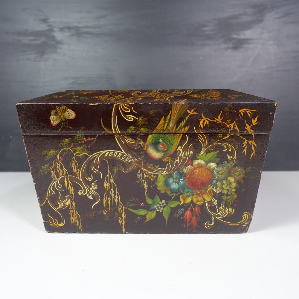 A 19th-century dark brown wooden box decorated with painted floral patterns, birds, gilt scrollwork, and a metal keyhole. View IV