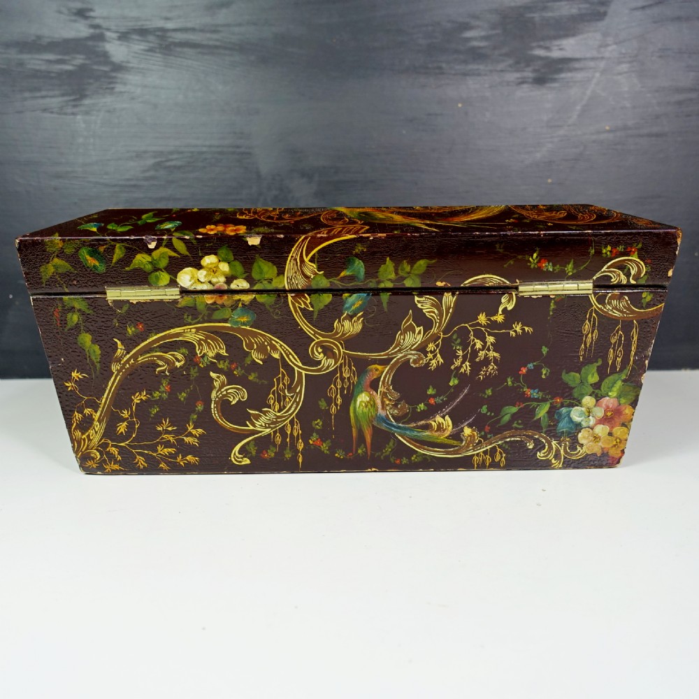 A 19th-century dark brown wooden box decorated with painted floral patterns, birds, gilt scrollwork, and a metal keyhole. View V