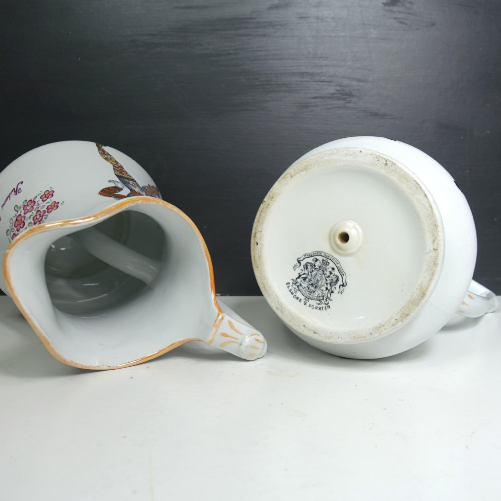 A pair of white Victorian ironstone puzzle jugs featuring hand-painted jester figures in colourful attire. View VI