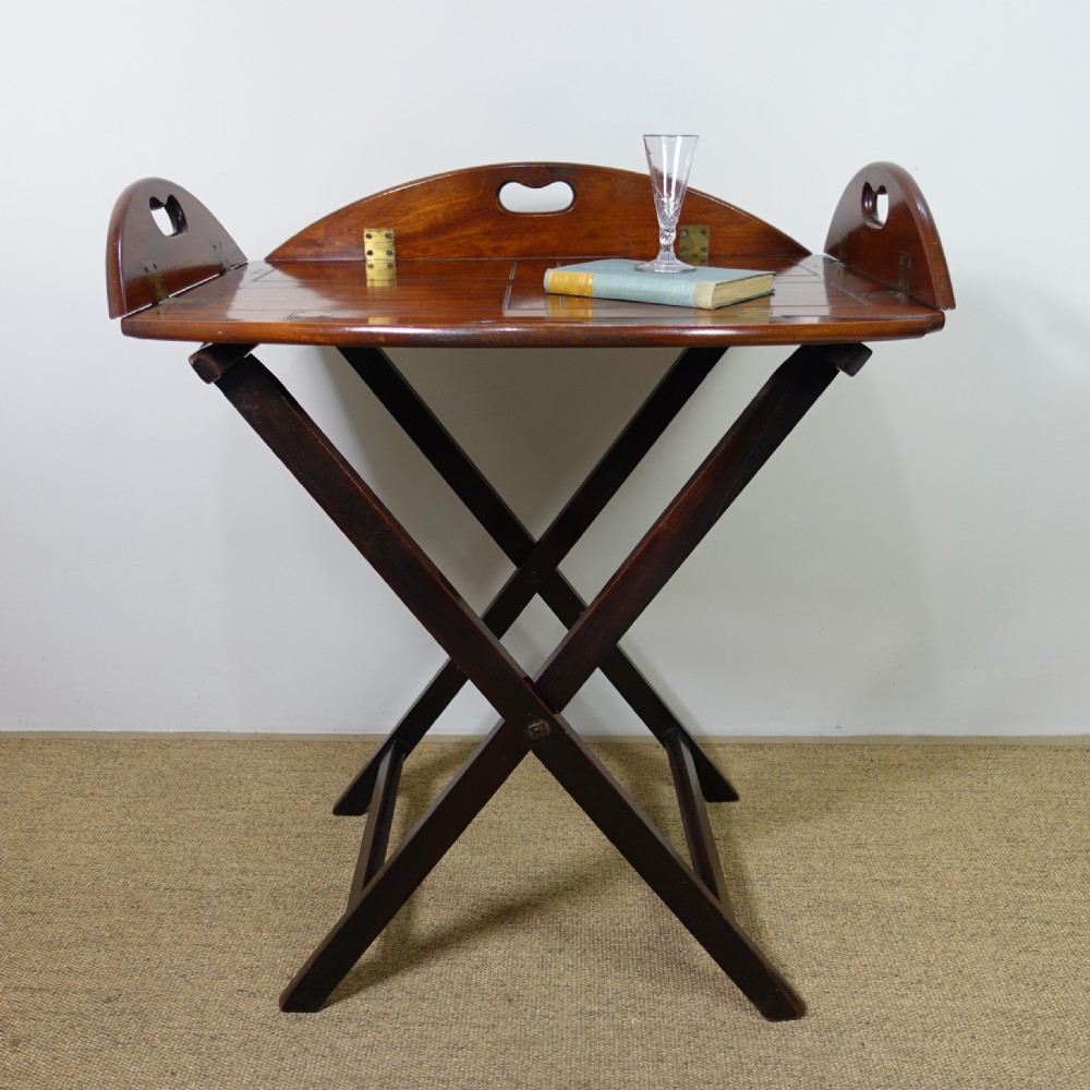 A George III mahogany butlers tray with hinged gallery sides resting on a folding cross-frame stand. View VII