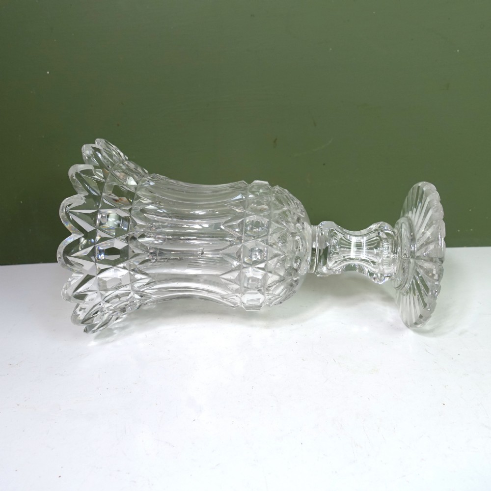 A 19th-century clear cut glass vase featuring a flared scalloped rim, geometric diamond patterns, fluted sides, and a stemmed pedestal base. View V