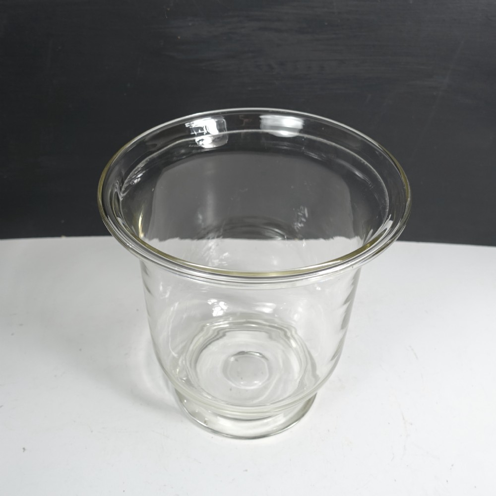 A large clear blown glass vase featuring a flared rim, a contoured body, and a circular moulded base. View VI