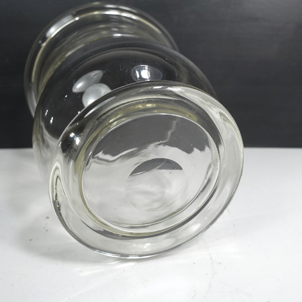 A large clear blown glass vase featuring a flared rim, a contoured body, and a circular moulded base. View VIII