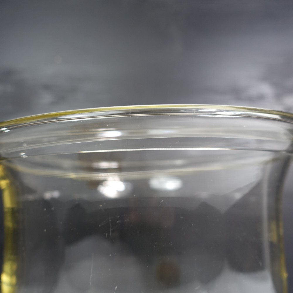 A large clear blown glass vase featuring a flared rim, a contoured body, and a circular moulded base. View IX