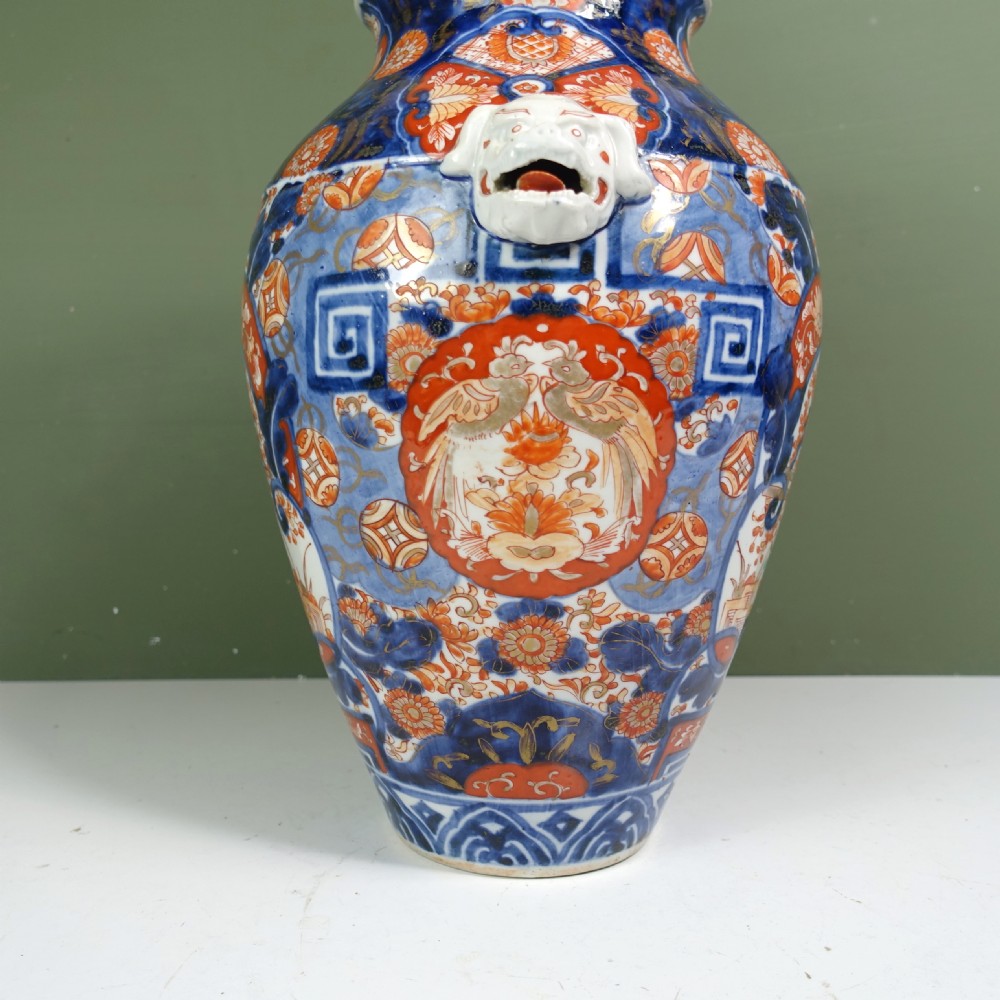 A 19th-century Japanese Imari porcelain vase featuring blue, iron-red, and orange hand-painted floral decoration and side handles. View V