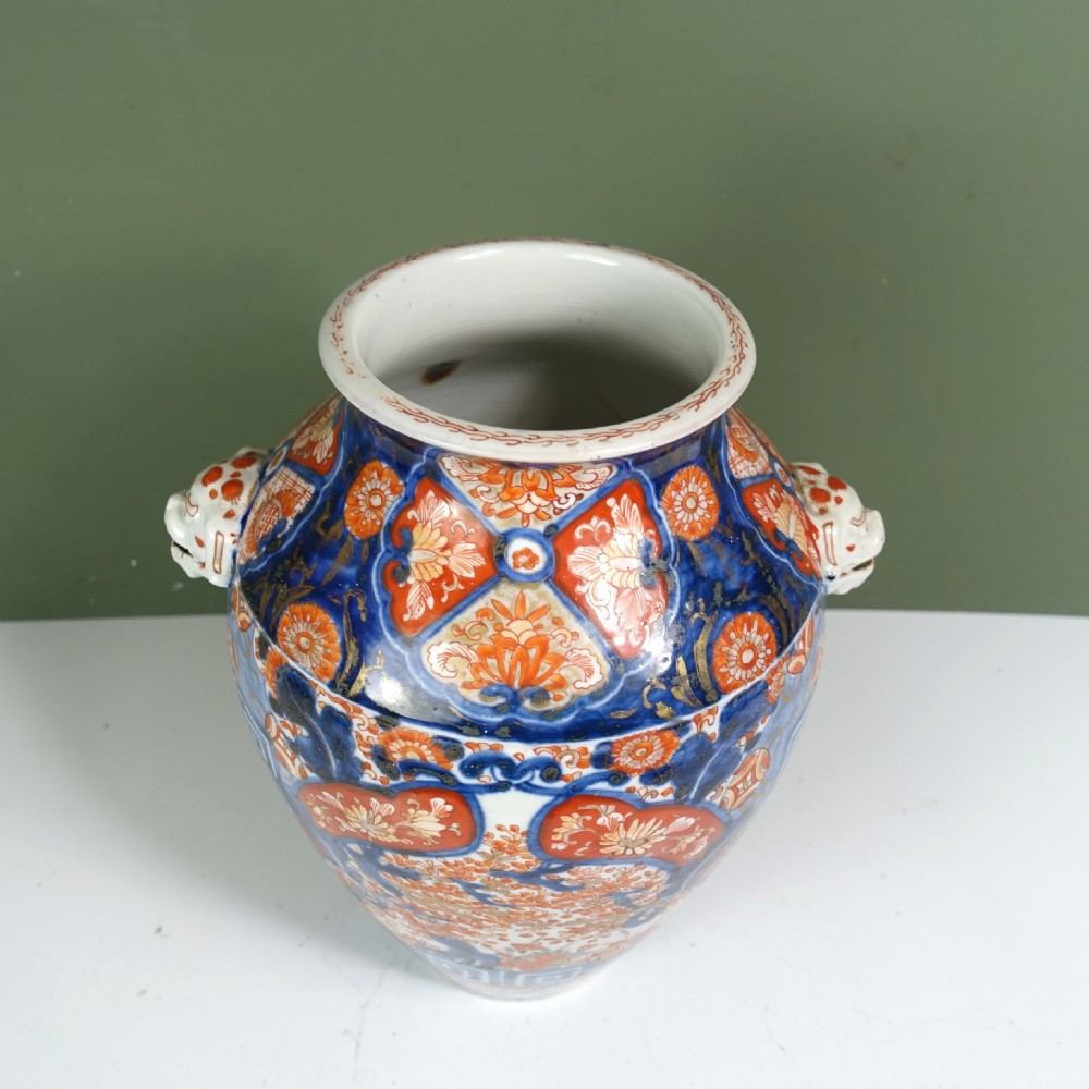 A 19th-century Japanese Imari porcelain vase featuring blue, iron-red, and orange hand-painted floral decoration and side handles. View VII