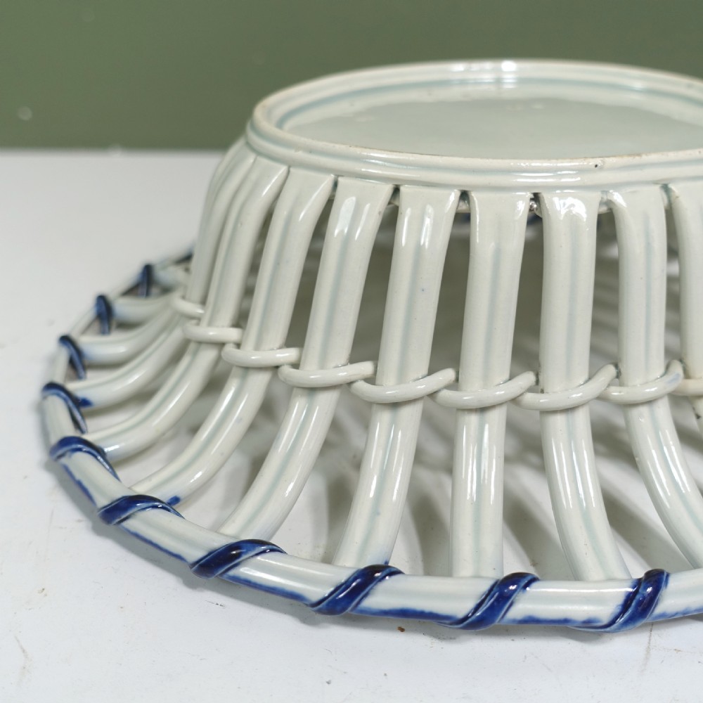 An early nineteenth-century oval pearlware ceramic basket featuring openwork lattice walls, a woven interior base, and a blue twisted rope rim. View VIII