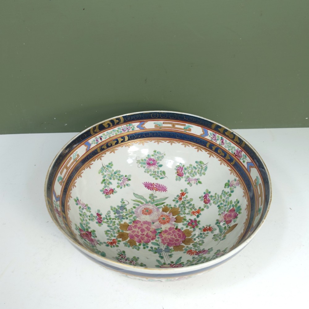 A 19th-century Chinese export porcelain centre bowl decorated with hand-painted pink floral motifs, green foliage, and a cobalt blue rim featuring gilt scrollwork. View II