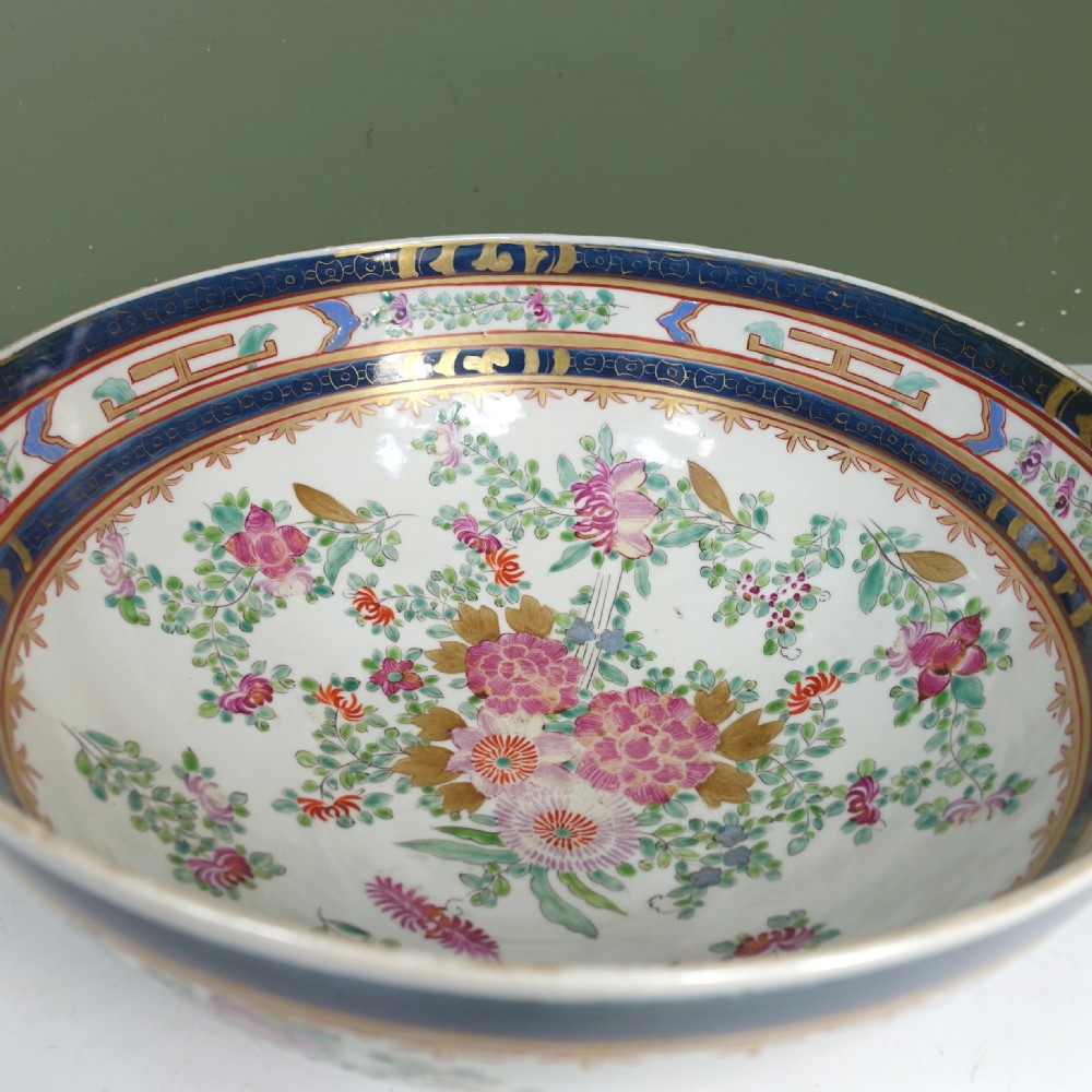 A 19th-century Chinese export porcelain centre bowl decorated with hand-painted pink floral motifs, green foliage, and a cobalt blue rim featuring gilt scrollwork. View VI