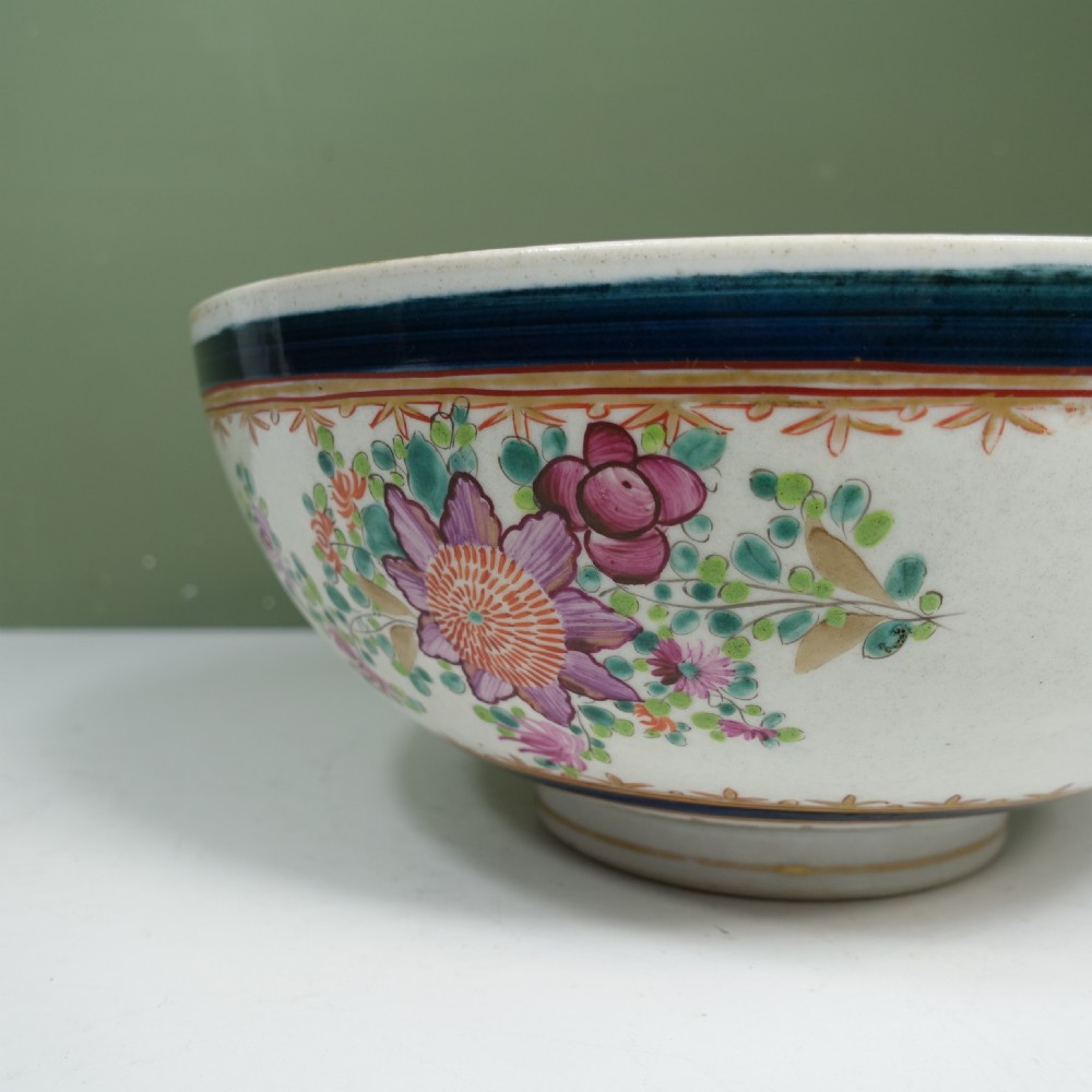 A 19th-century Chinese export porcelain centre bowl decorated with hand-painted pink floral motifs, green foliage, and a cobalt blue rim featuring gilt scrollwork. View VII