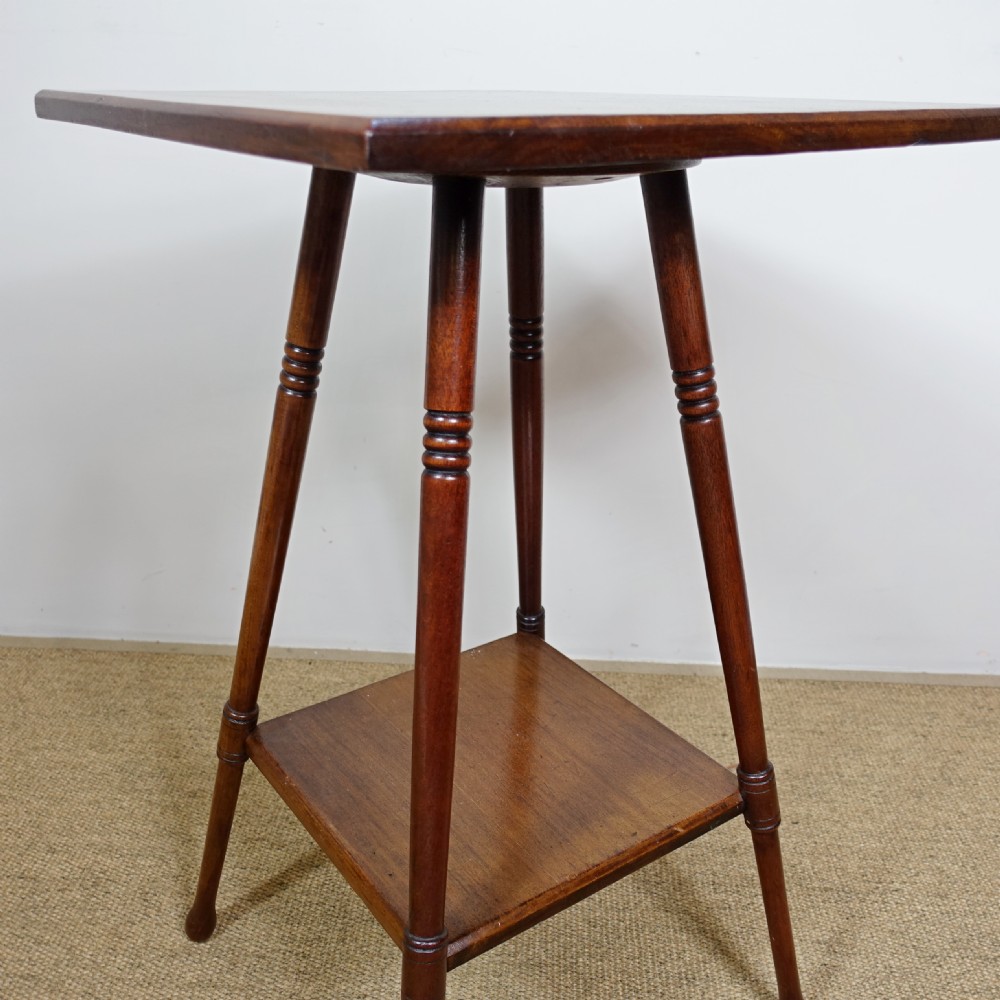 A late 19th-century mahogany occasional table featuring a square top, turned splayed legs, and a square lower undertier shelf. View V