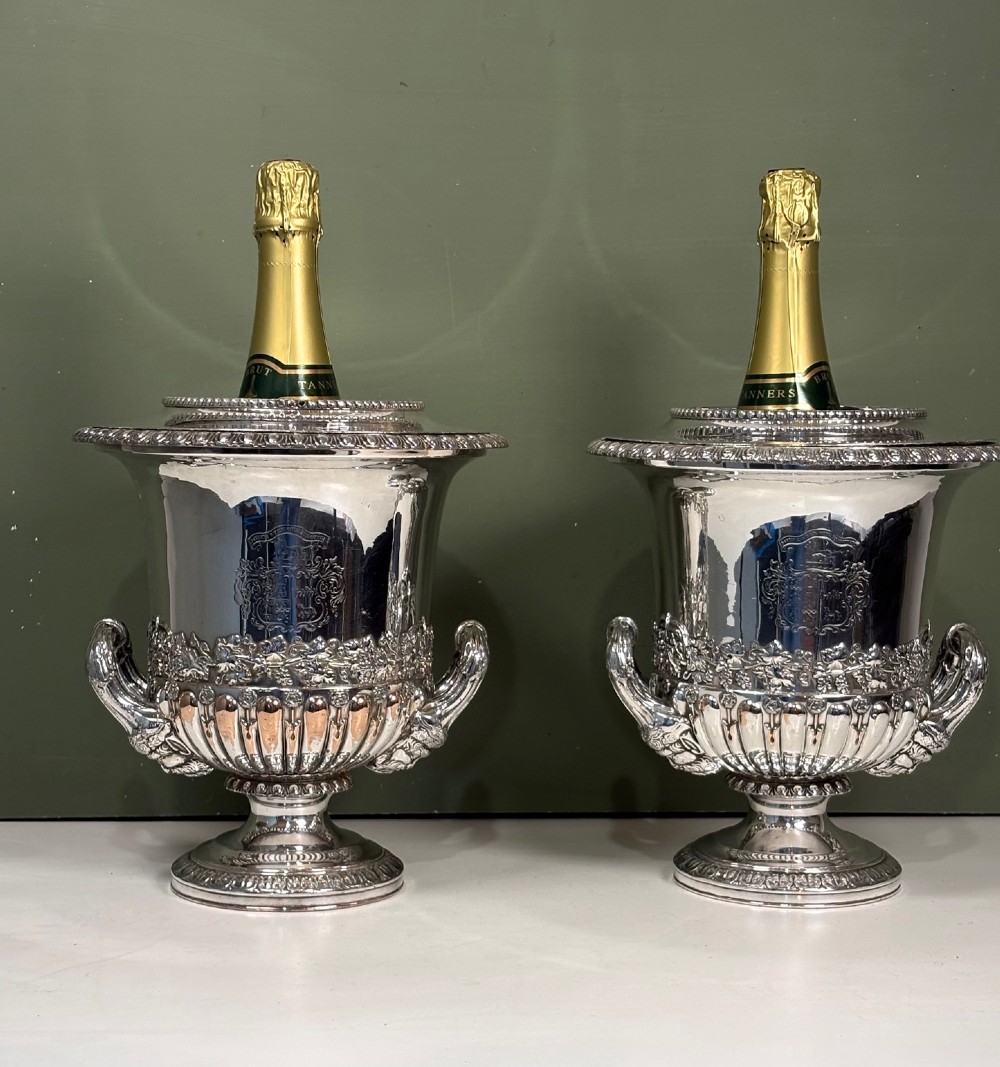 A pair of 19th-century silver-plated urn-shaped wine coolers featuring engraved crests, double scroll handles, fluted bases, and removable liners. View II