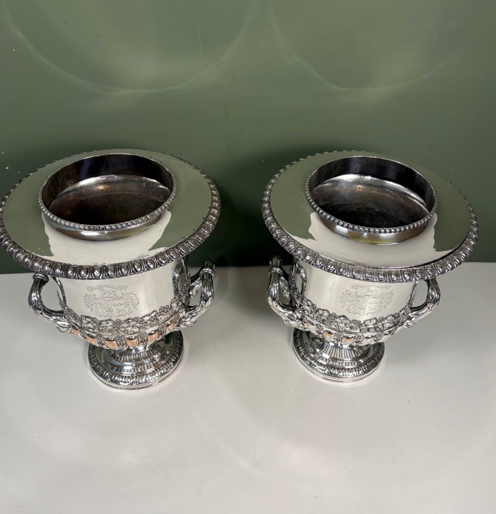 A pair of 19th-century silver-plated urn-shaped wine coolers featuring engraved crests, double scroll handles, fluted bases, and removable liners. View III