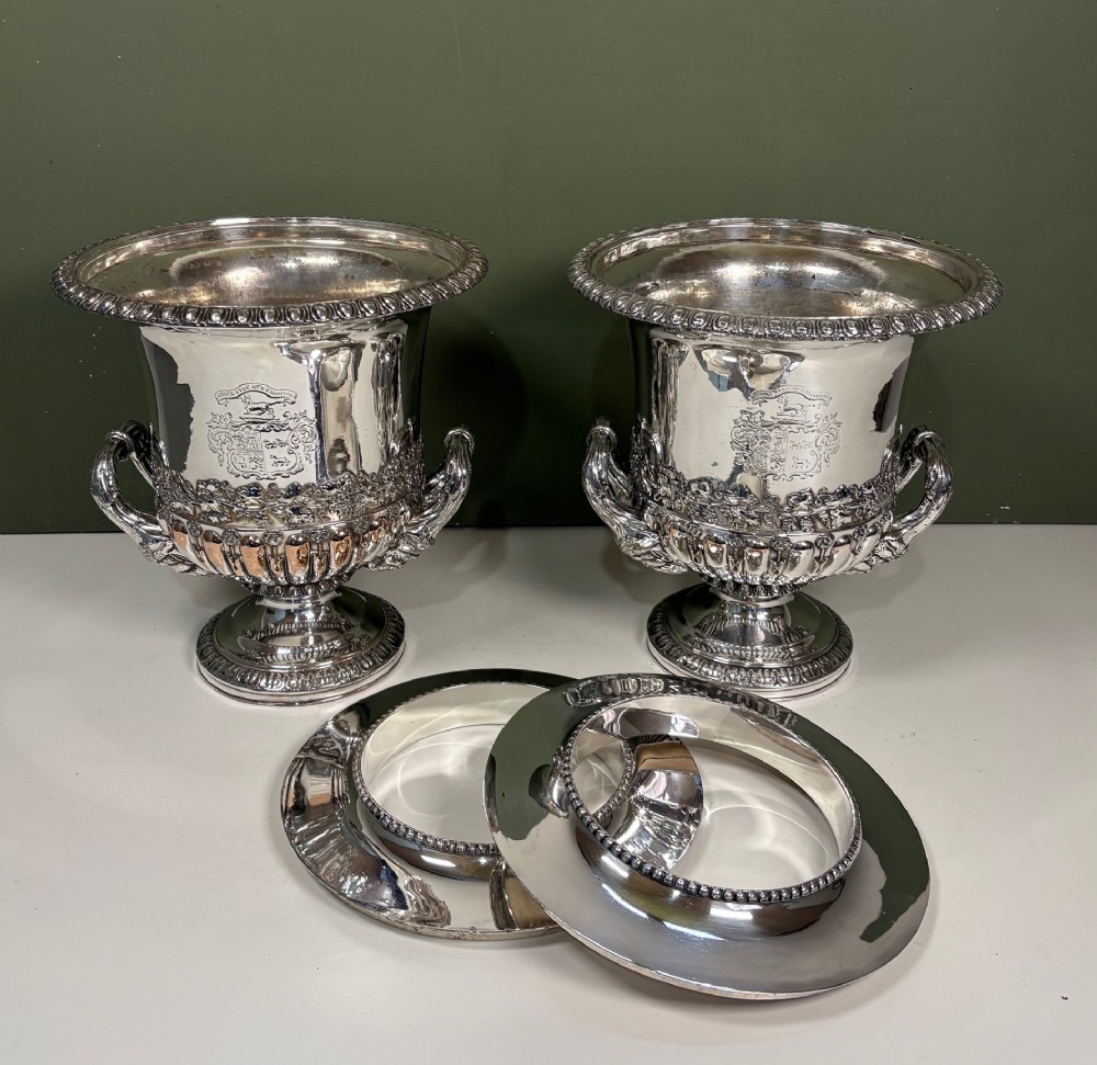 A pair of 19th-century silver-plated urn-shaped wine coolers featuring engraved crests, double scroll handles, fluted bases, and removable liners. View IV
