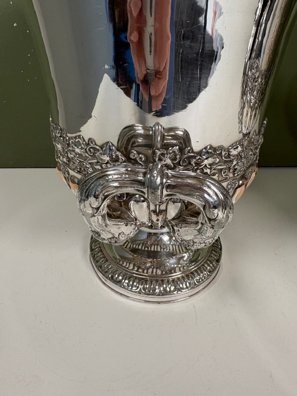 A pair of 19th-century silver-plated urn-shaped wine coolers featuring engraved crests, double scroll handles, fluted bases, and removable liners. View VII
