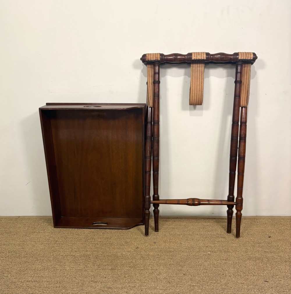 A 19th-century mahogany butlers tray with cut-out handles resting on a turned folding X-frame stand. View VI