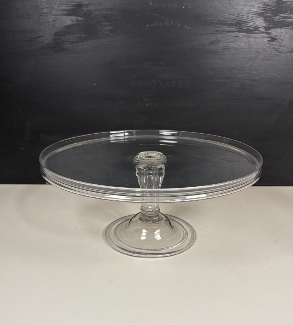 A clear glass George III tazza featuring a wide circular tray supported by a turned stem and a circular footed base. View II