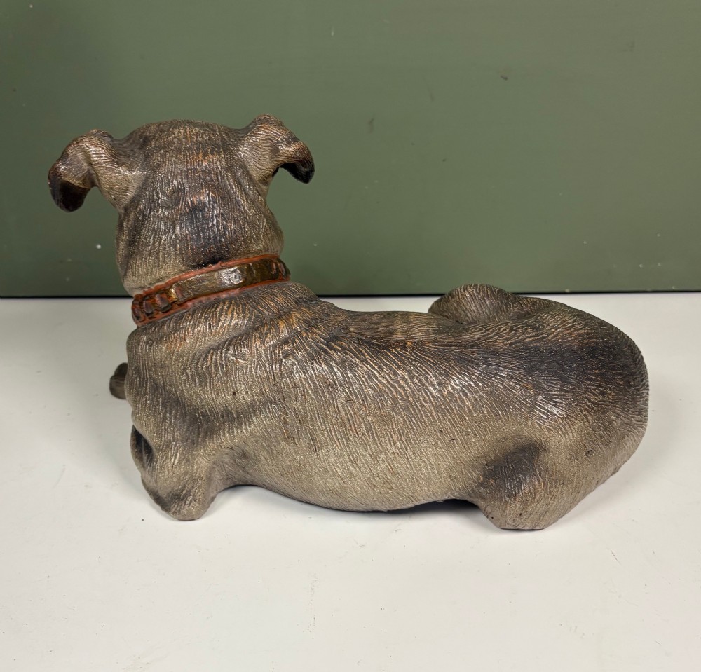 A nineteenth-century ceramic figurine depicting a reclining pug dog with a textured dark brown finish and a painted collar. View III