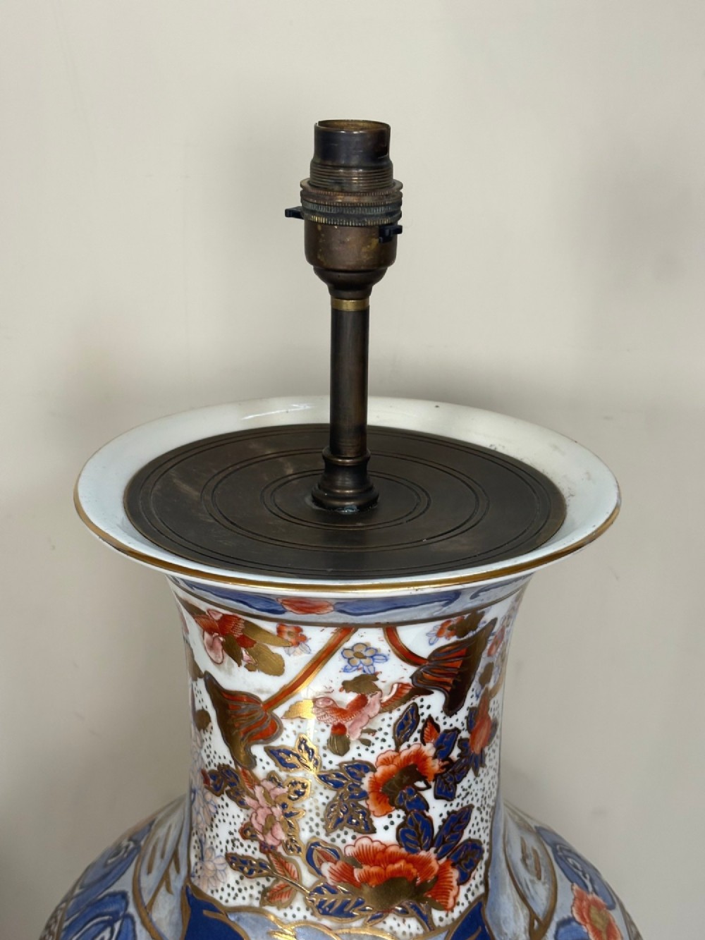 A pair of large ceramic baluster-shaped lamps decorated with traditional Japanese Imari floral patterns in blue, red, and gold, mounted on circular wooden plinths. View IV