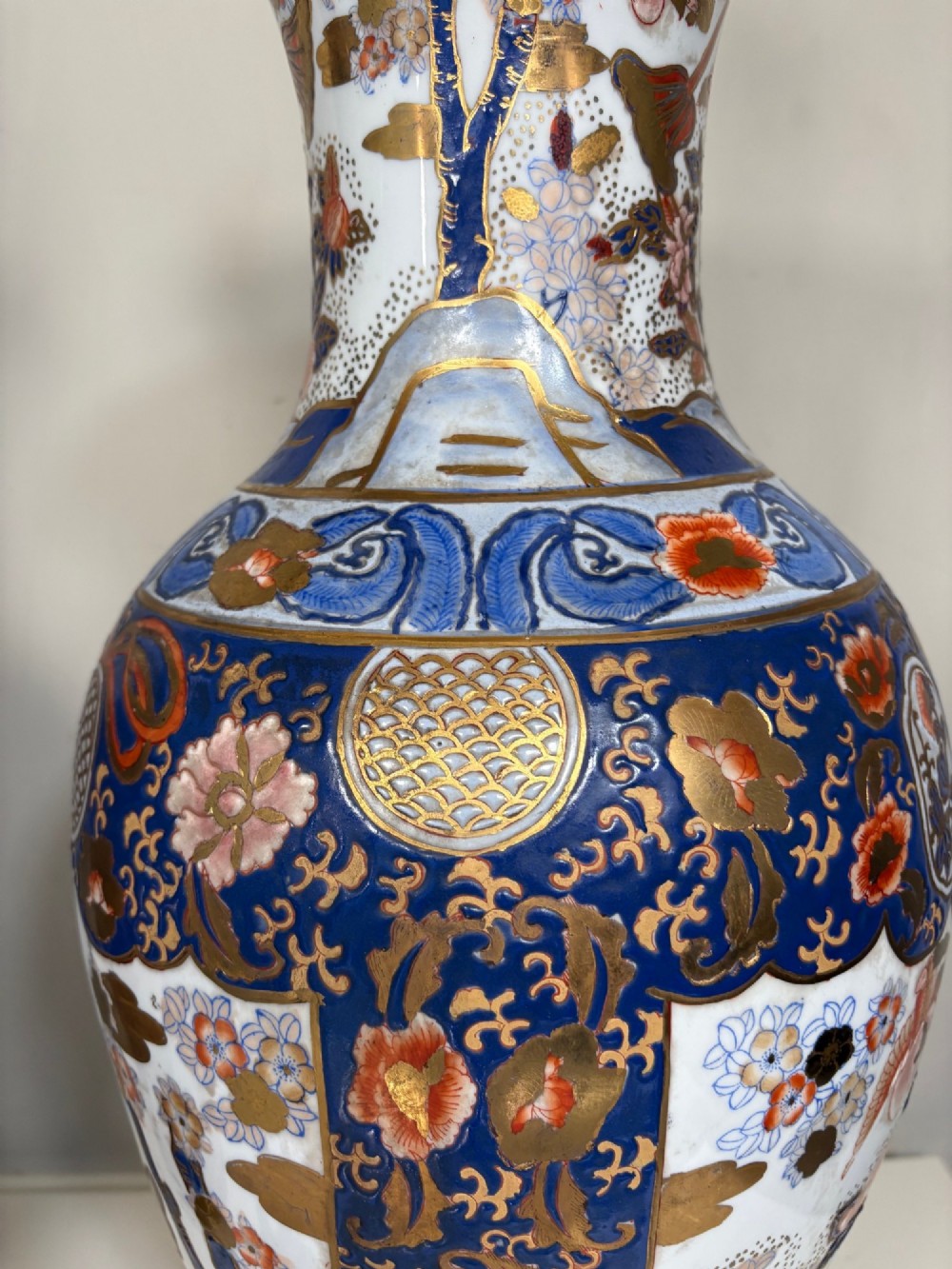 A pair of large ceramic baluster-shaped lamps decorated with traditional Japanese Imari floral patterns in blue, red, and gold, mounted on circular wooden plinths. View VI