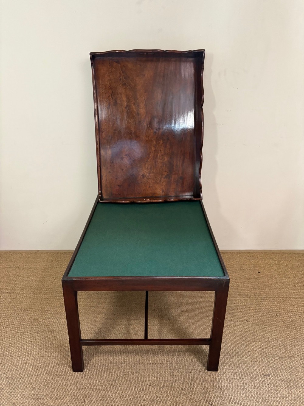 A George III mahogany butlers tray table featuring a scalloped gallery edge with cut-out handles supported by a square-leg wooden stand with cross stretchers. View V
