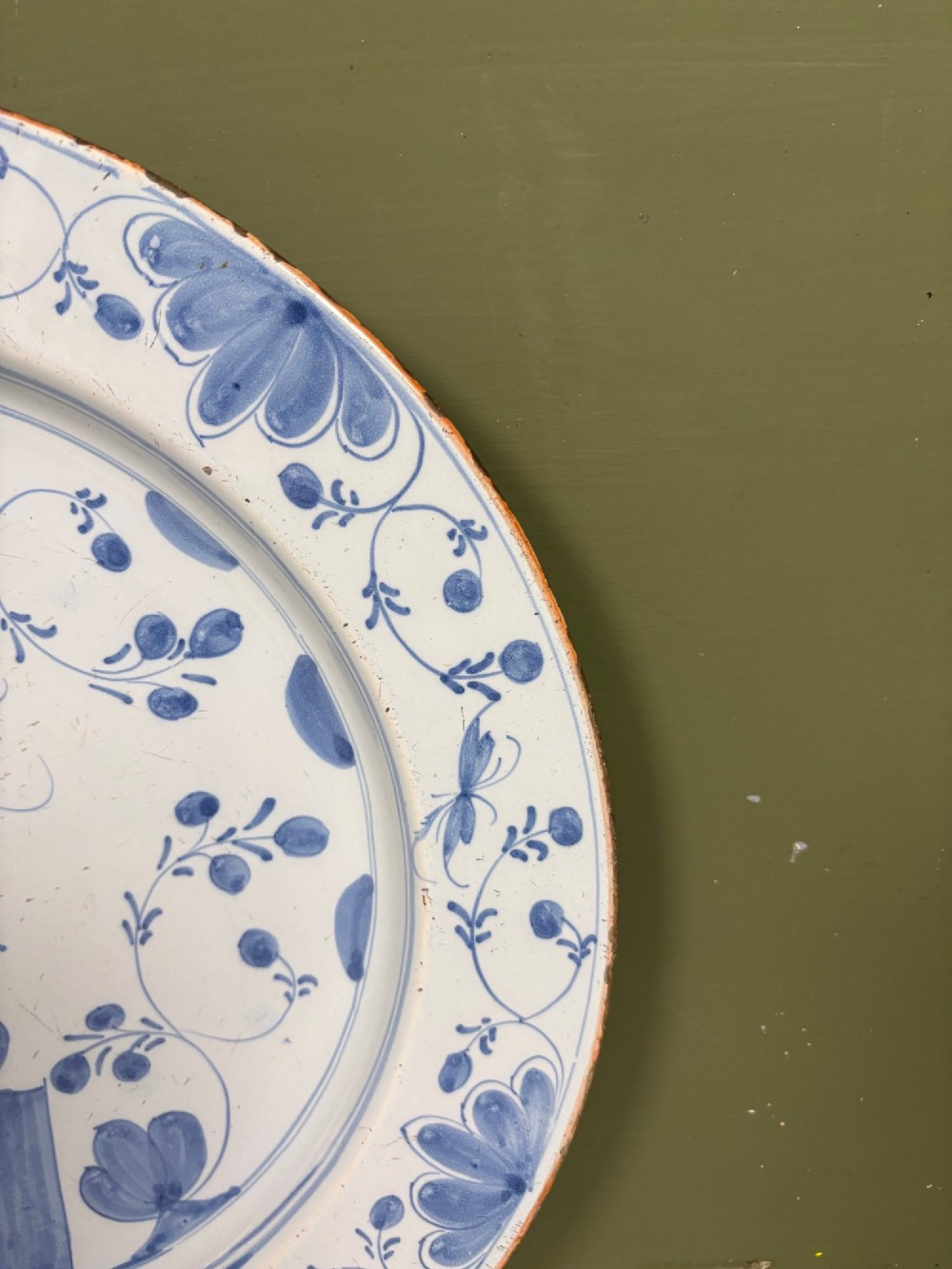 An 18th-century circular blue and white Delftware charger decorated with hand-painted floral and insect motifs. View III