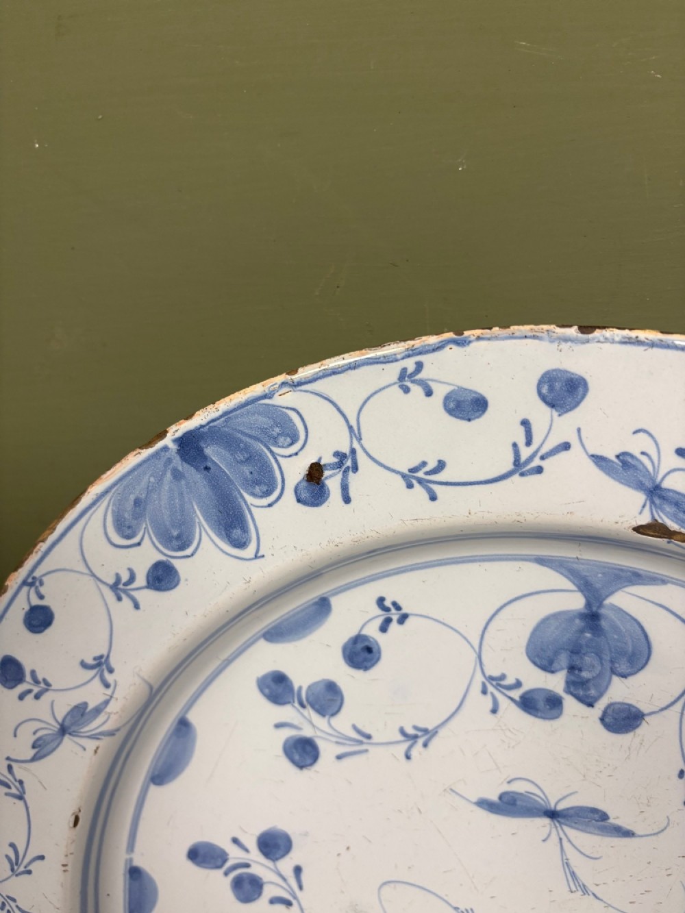 An 18th-century circular blue and white Delftware charger decorated with hand-painted floral and insect motifs. View IV