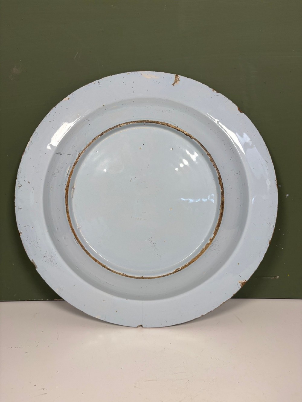 An 18th-century circular blue and white Delftware charger decorated with hand-painted floral and insect motifs. View V
