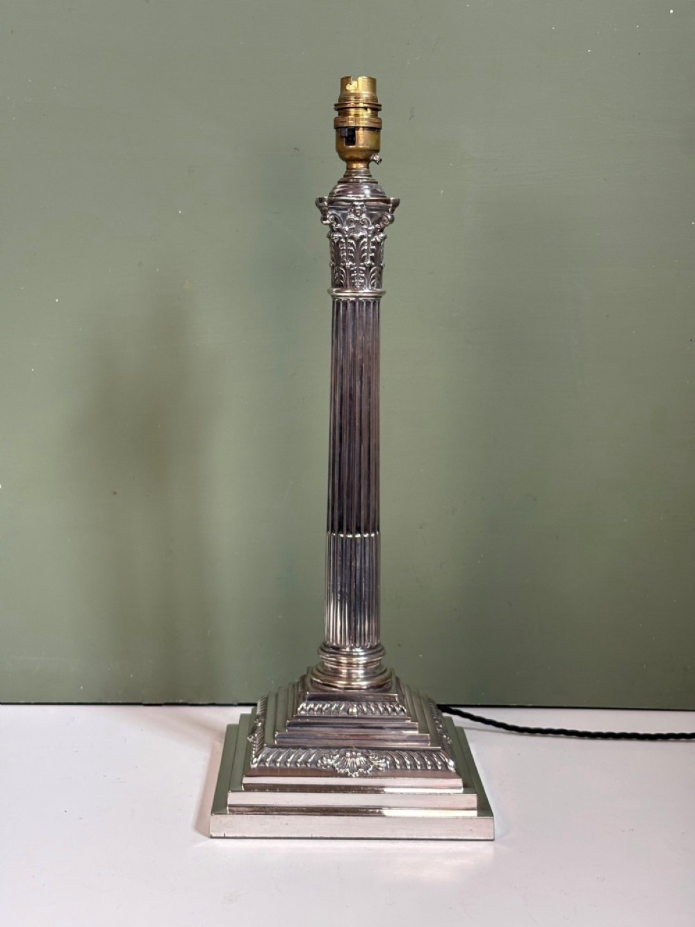 A 19th-century silver-plated Corinthian column table lamp base featuring a fluted stem, detailed capital, and stepped square pedestal base.