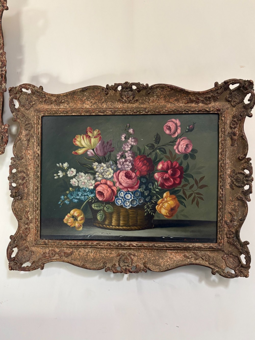 A pair of 19th-century oil paintings displaying botanical floral arrangements in woven baskets within ornate swept gilt frames. View III