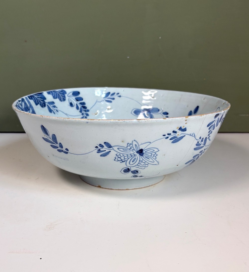 An 18th-century blue and white tin-glazed earthenware bowl with hand-painted cobalt blue botanical decoration. View II