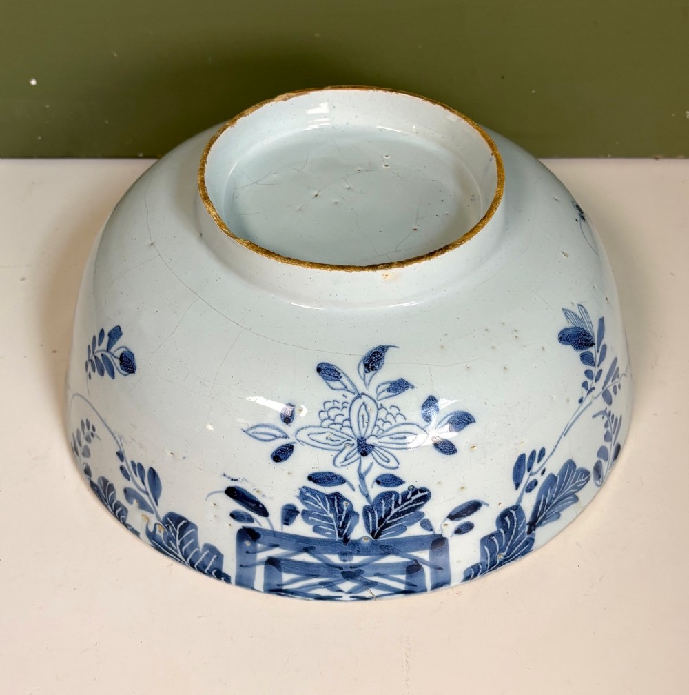 An 18th-century blue and white tin-glazed earthenware bowl with hand-painted cobalt blue botanical decoration. View IV