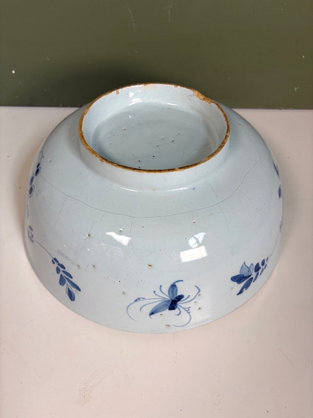 An 18th-century blue and white tin-glazed earthenware bowl with hand-painted cobalt blue botanical decoration. View V