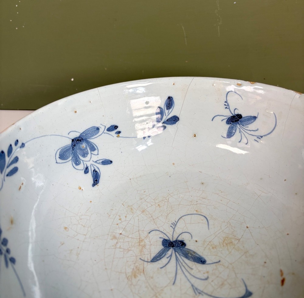 An 18th-century blue and white tin-glazed earthenware bowl with hand-painted cobalt blue botanical decoration. View VI