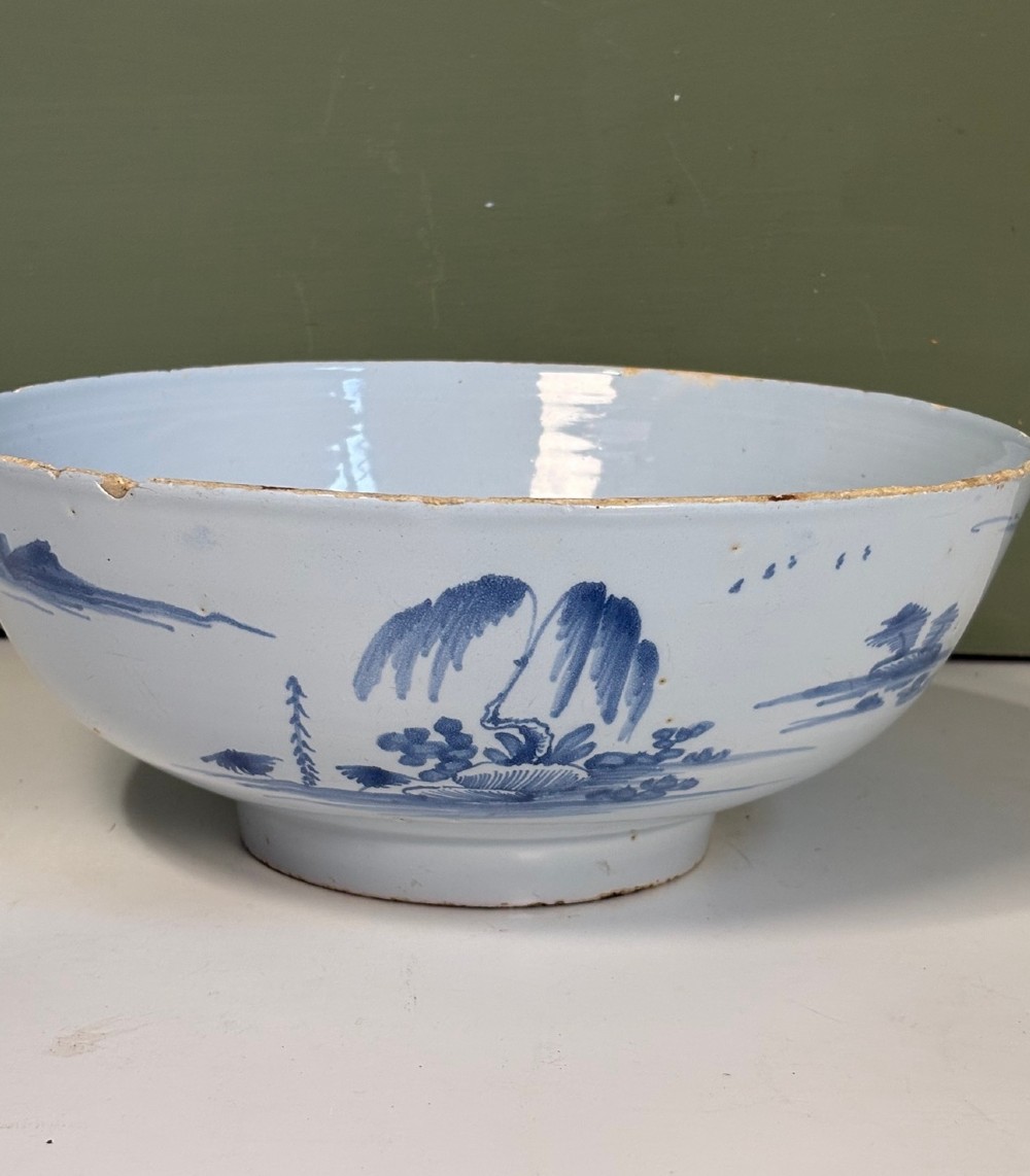 An 18th-century tin-glazed earthenware bowl decorated with hand-painted cobalt blue figurative scenes on a footed base. View II