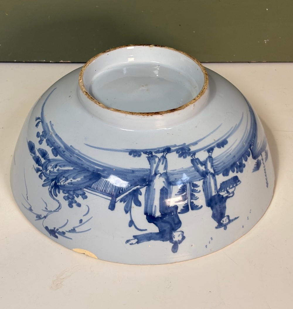 An 18th-century tin-glazed earthenware bowl decorated with hand-painted cobalt blue figurative scenes on a footed base. View IV