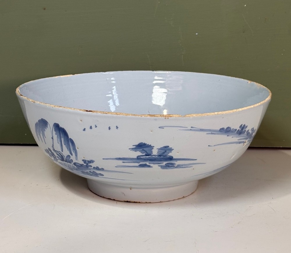 An 18th-century tin-glazed earthenware bowl decorated with hand-painted cobalt blue figurative scenes on a footed base. View VI