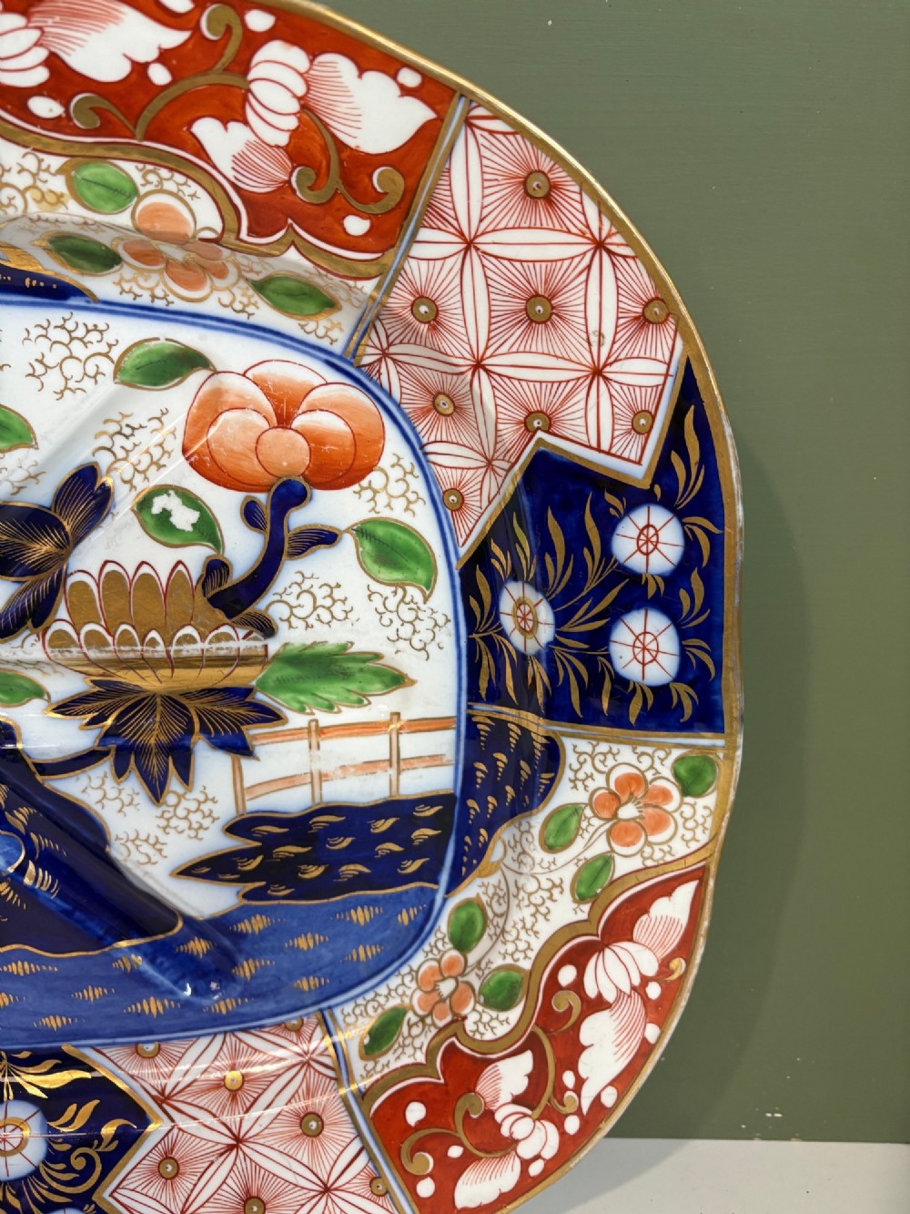 A large oval 19th-century Coalport porcelain meat platter featuring an Imari pattern with cobalt blue, iron red, and gold leaf detailing around a moulded tree-and-well channel. View IV