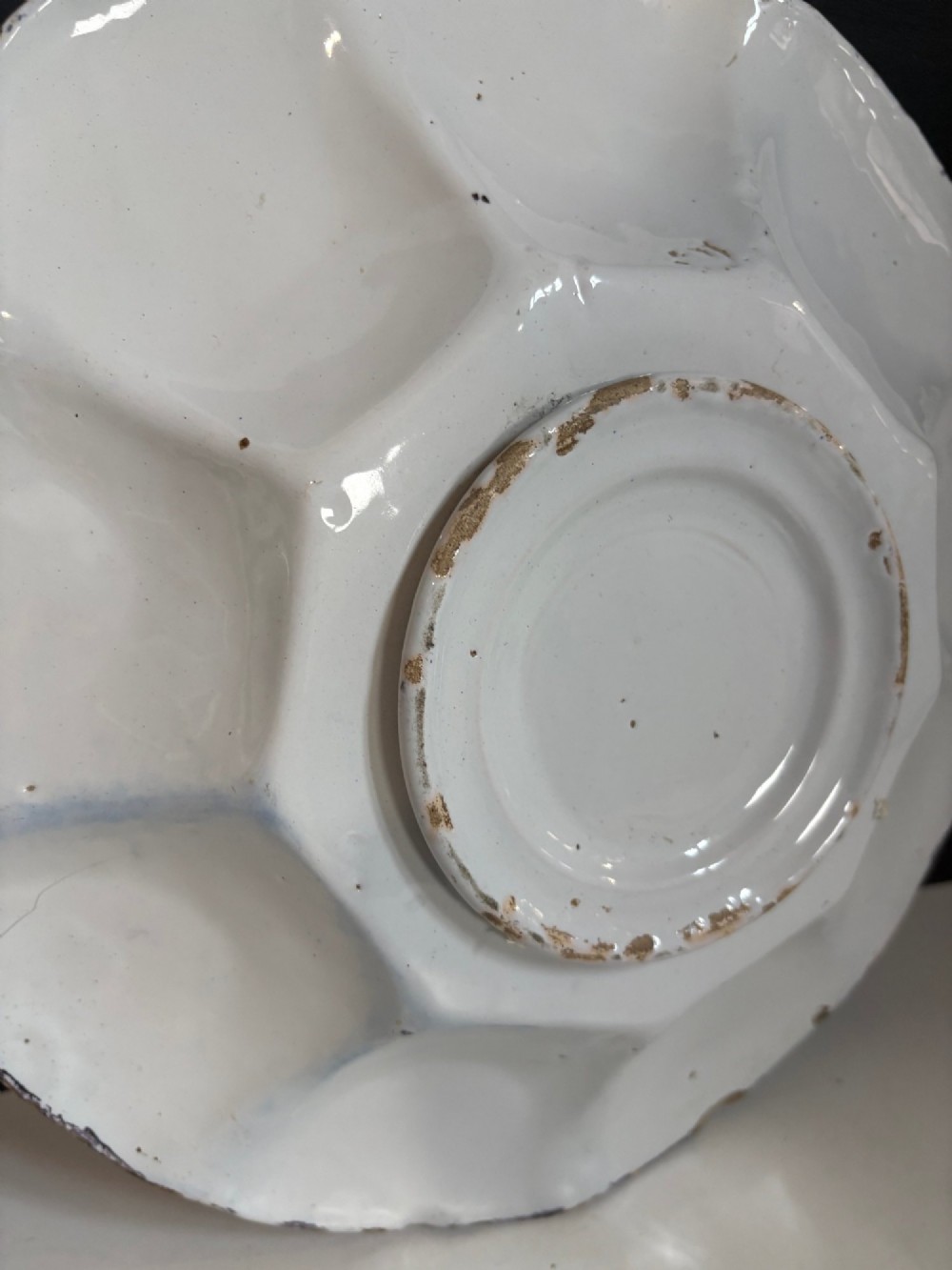 A pair of circular 18th-century tin-glazed earthenware dishes featuring hand-painted manganese purple and yellow chinoiserie figures surrounded by scalloped edges. View VI