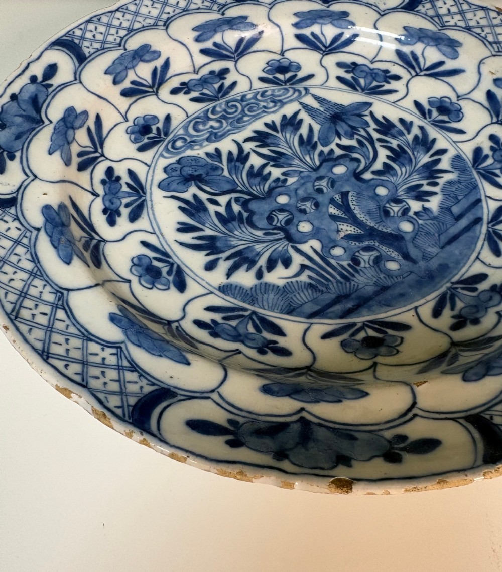 A circular 18th-century tin-glazed earthenware dish decorated with hand-painted cobalt blue floral motifs and geometric diaper borders on a white ground. View VI