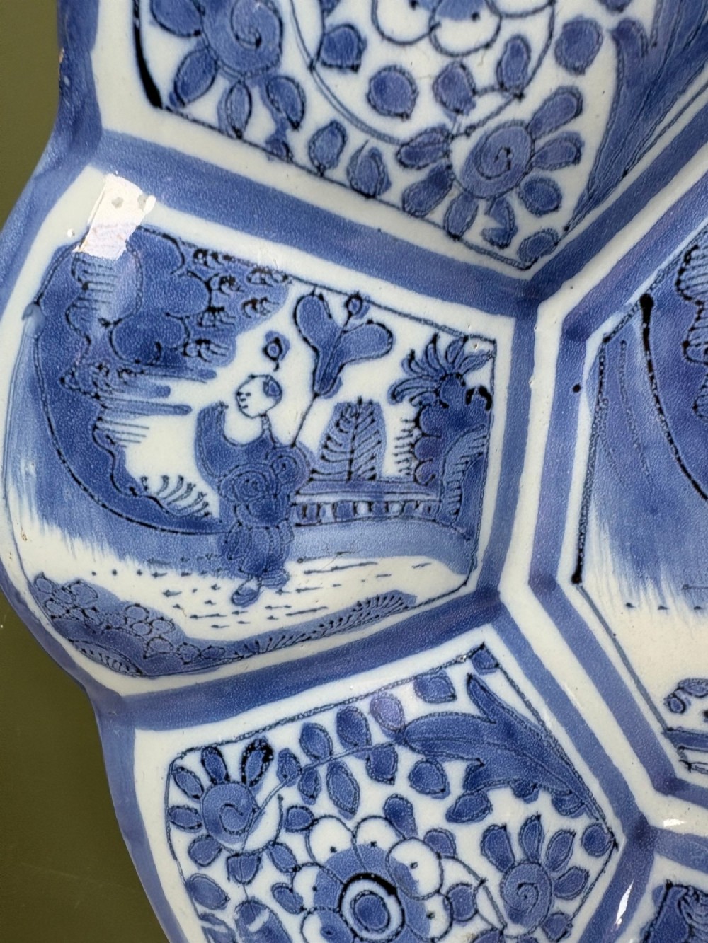An eighteenth-century lobed tin-glazed earthenware dish featuring cobalt blue hand-painted chinoiserie figures and floral scrollwork within segmented panels. View IV