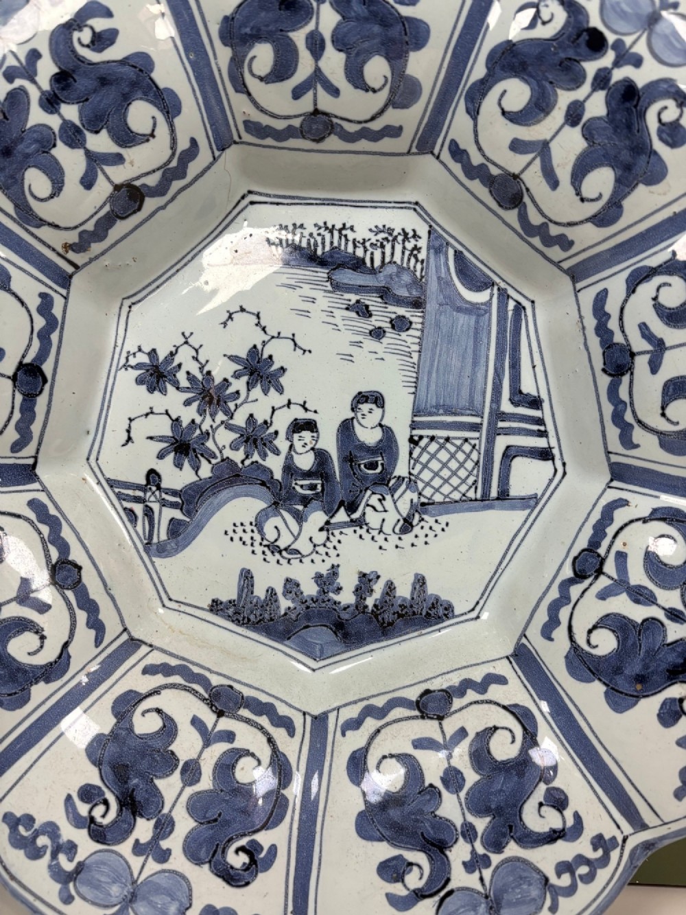 An 18th-century scalloped tin-glazed earthenware dish decorated with hand-painted cobalt blue Chinoiserie figures and floral patterns. View II