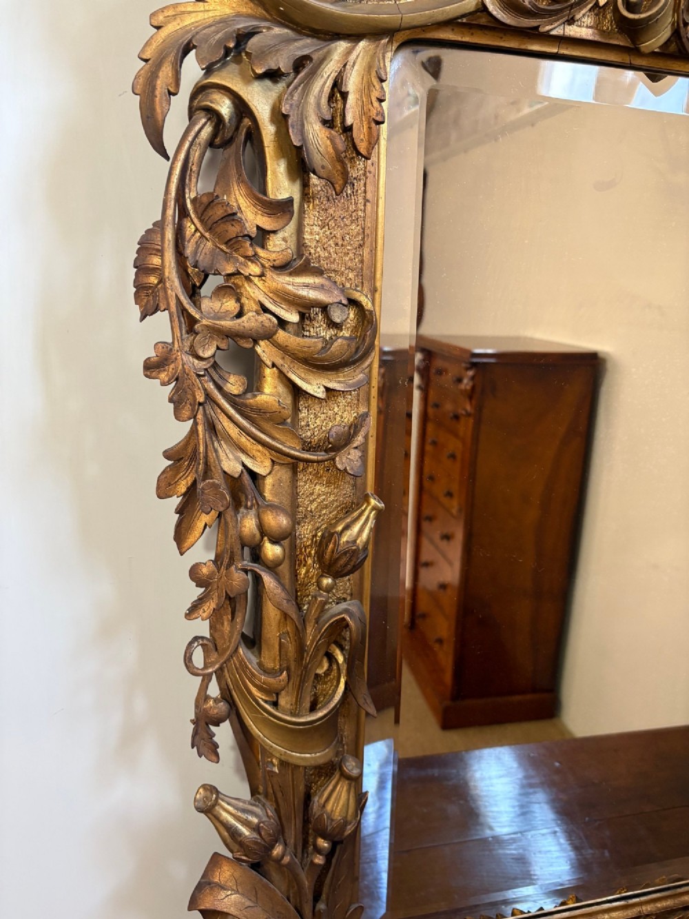 A 19th-century Rococo Revival carved giltwood wall mirror featuring ornate floral cresting, acanthus leaf details, and a central mirror plate. View III