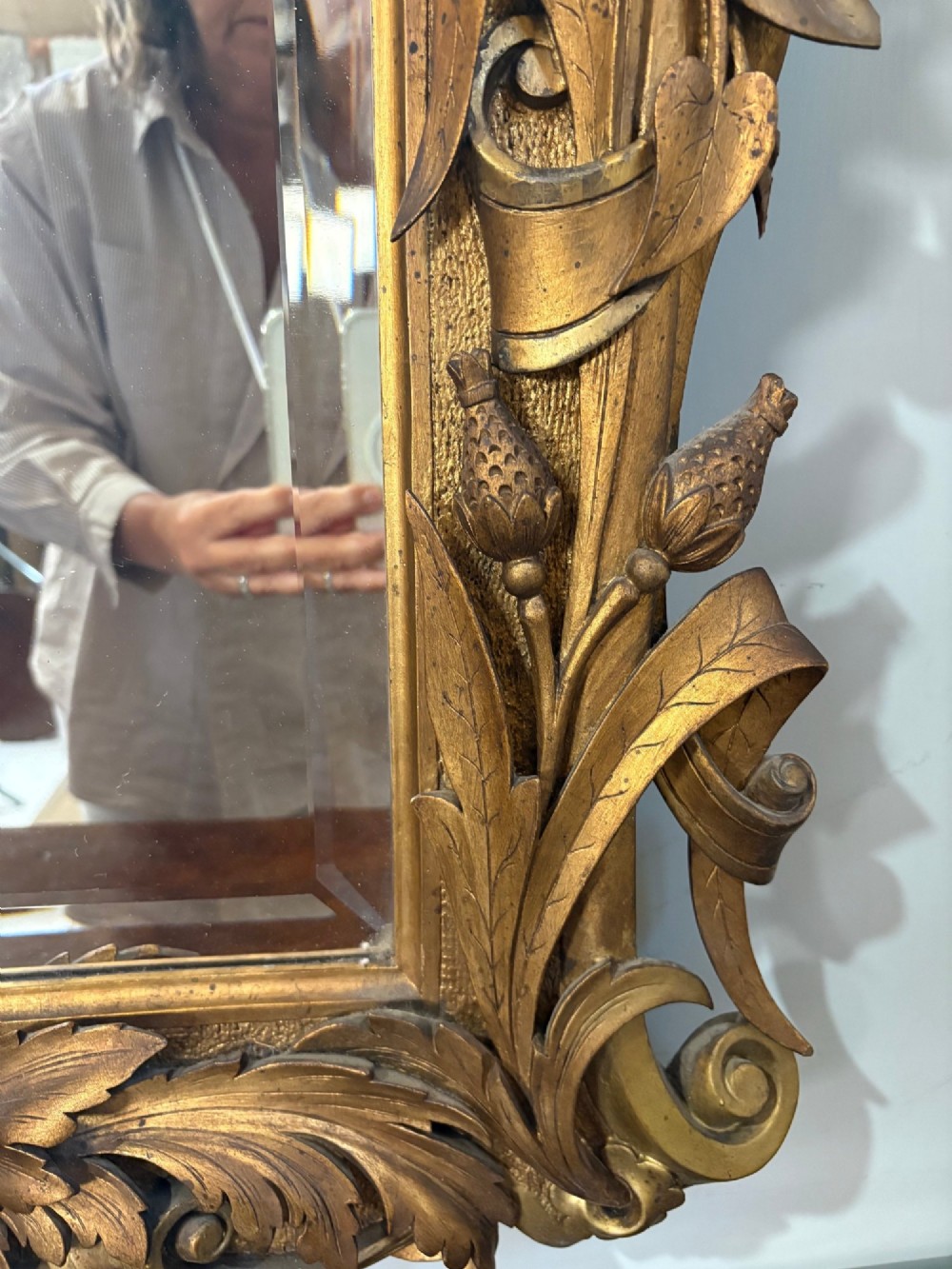 A 19th-century Rococo Revival carved giltwood wall mirror featuring ornate floral cresting, acanthus leaf details, and a central mirror plate. View IV