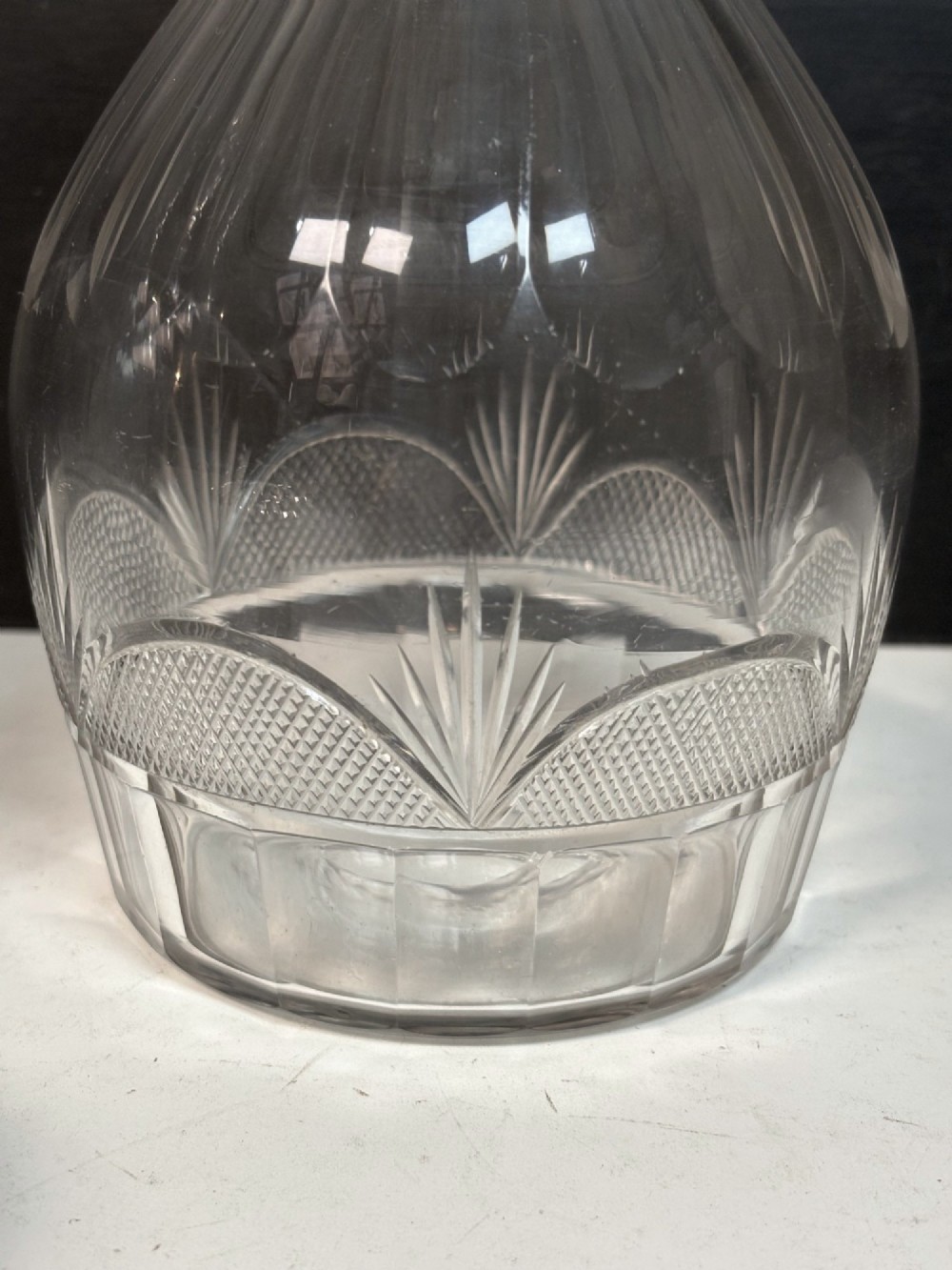 A pair of 19th-century clear cut glass decanters featuring triple neck rings, mushroom stoppers, and wheel-cut geometric panel details. View V