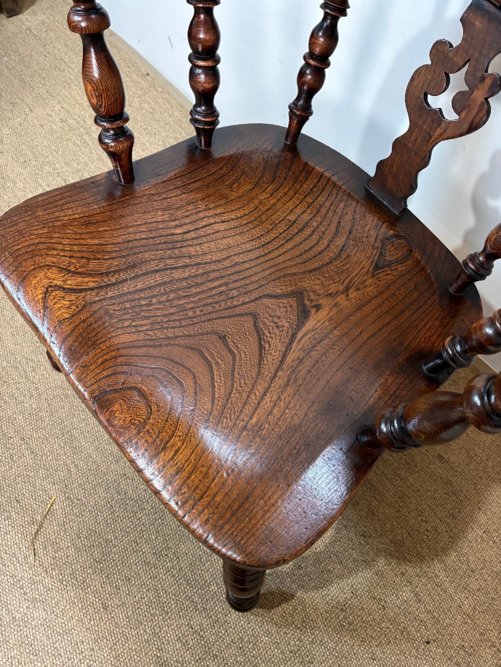 A 19th-century dark oak and elm Windsor armchair featuring a hoop back, central pierced splat, turned arm supports, and turned legs joined by stretchers. View VI