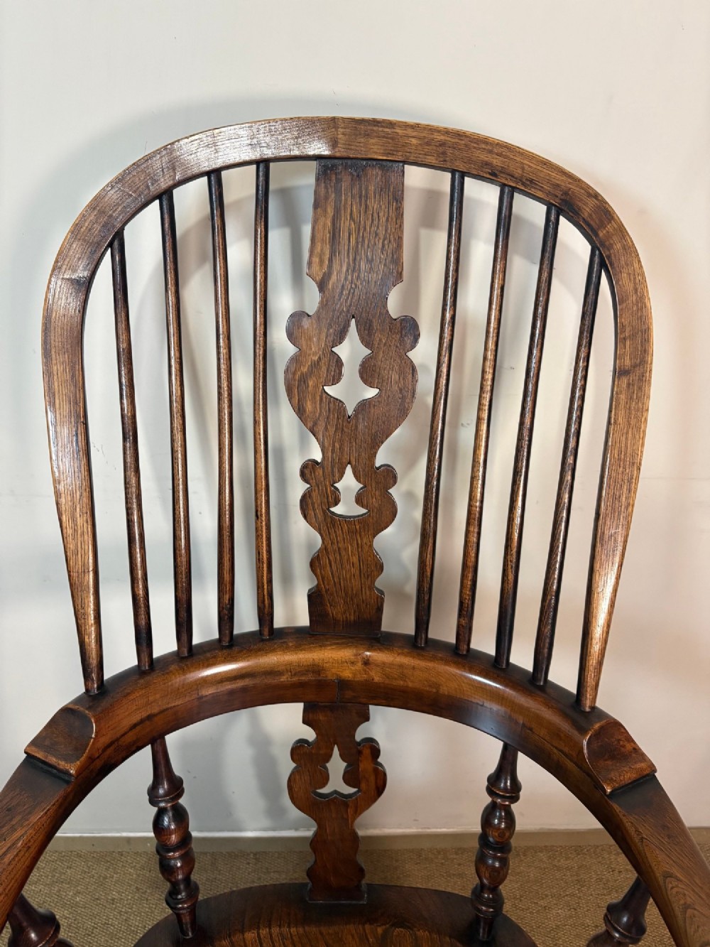 A 19th-century dark oak and elm Windsor armchair featuring a hoop back, central pierced splat, turned arm supports, and turned legs joined by stretchers. View VII