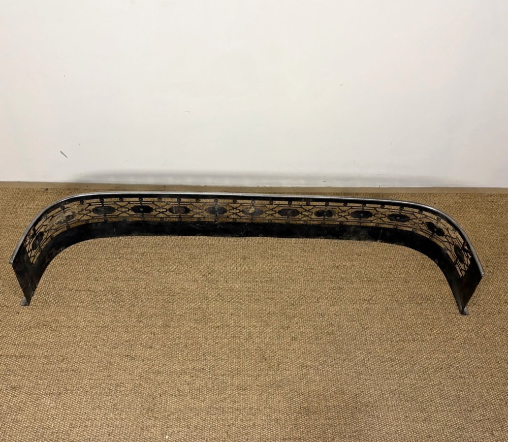 A nineteenth-century burnished steel fireplace fender featuring a curved front with geometric pierced fretwork and raised studs. View III
