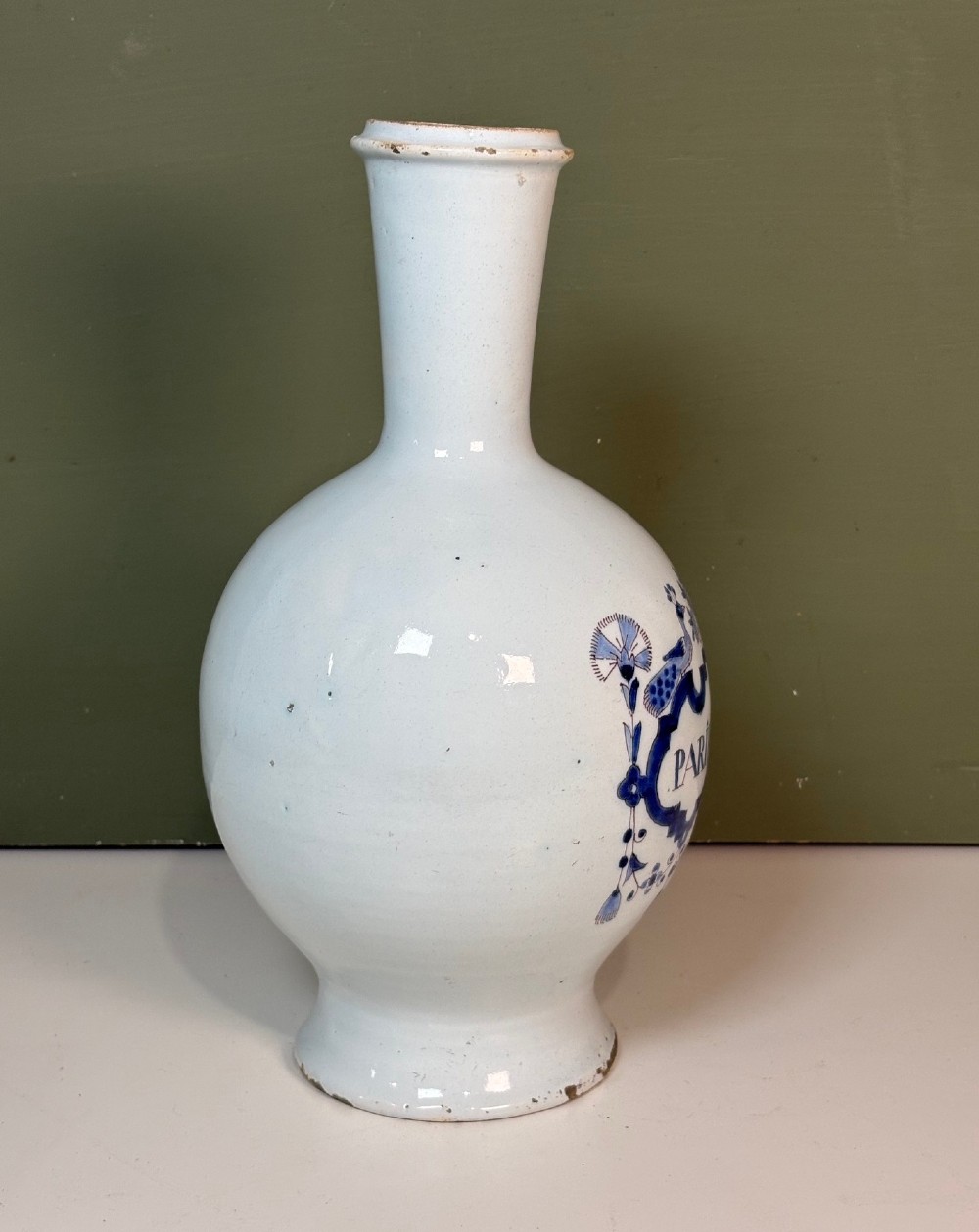 An 18th-century tin-glazed earthenware Delft apothecary bottle decorated with a hand-painted blue cartouche, peacocks, and Latin inscription. View III